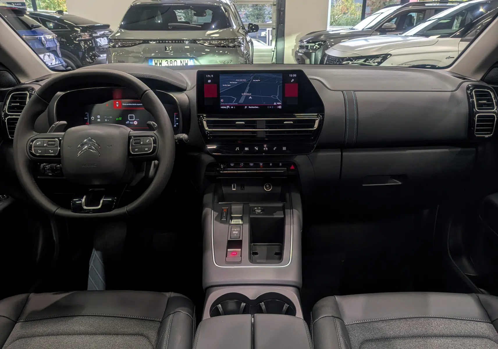 Vue intérieure avant du Citroën C5 Aircross 2025, tableau de bord noir avec écran tactile central et volant multifonction.