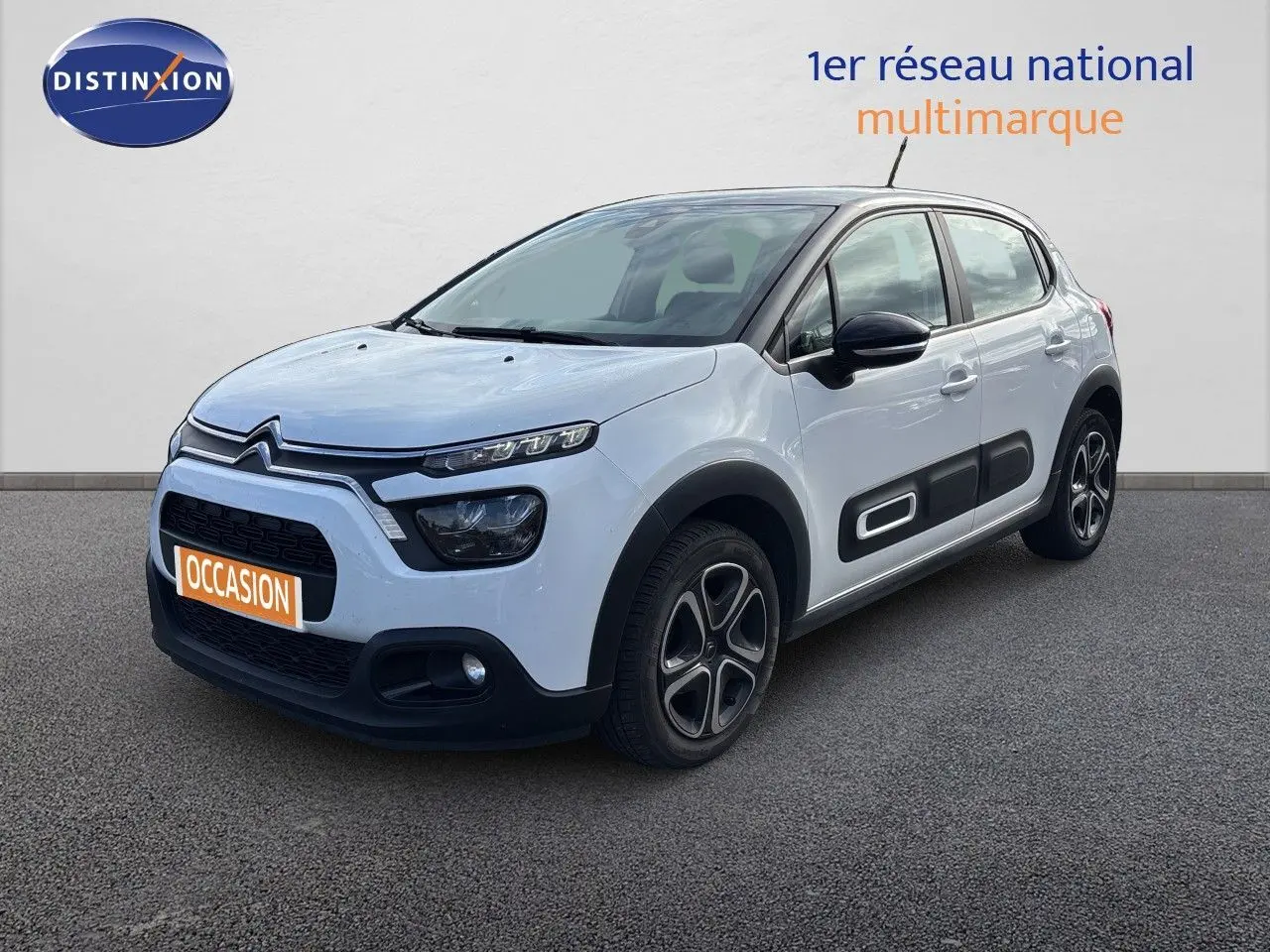 Citroën C3 blanc banquise vue 3/4 avant droit, avec protections latérales noires et jantes stylisées.