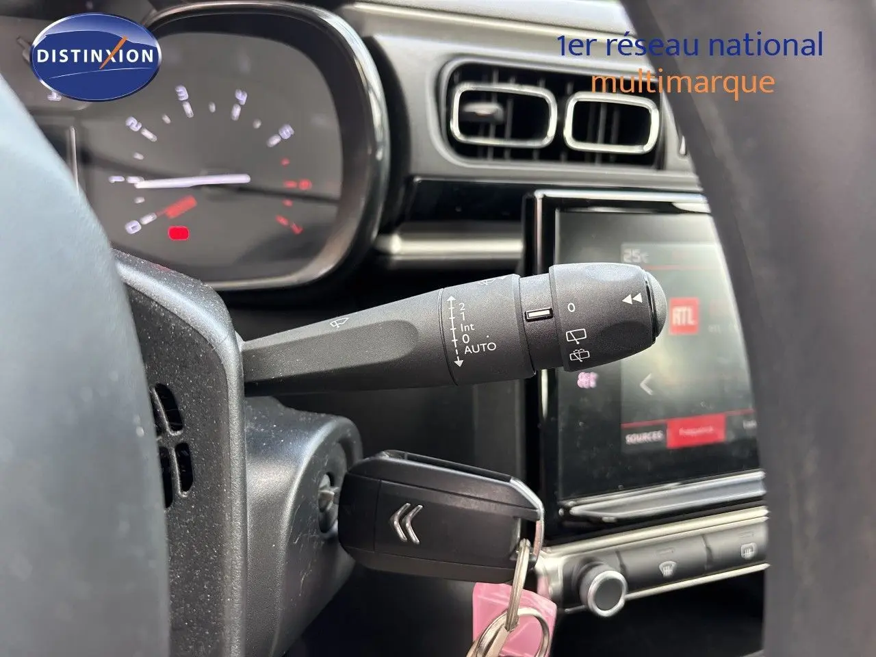 Gros plan sur la commande d’essuie-glace et le tableau de bord de la Citroën C3 blanche banquise, version 2022.