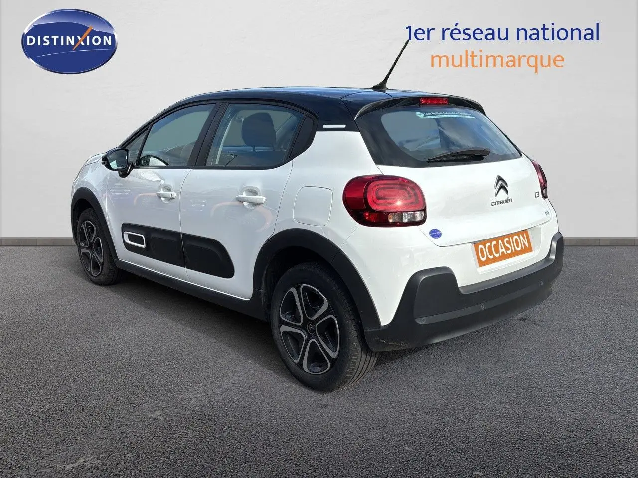 Citroën C3 blanc banquise vue 3/4 arrière droit, avec toit noir et protections latérales noires.