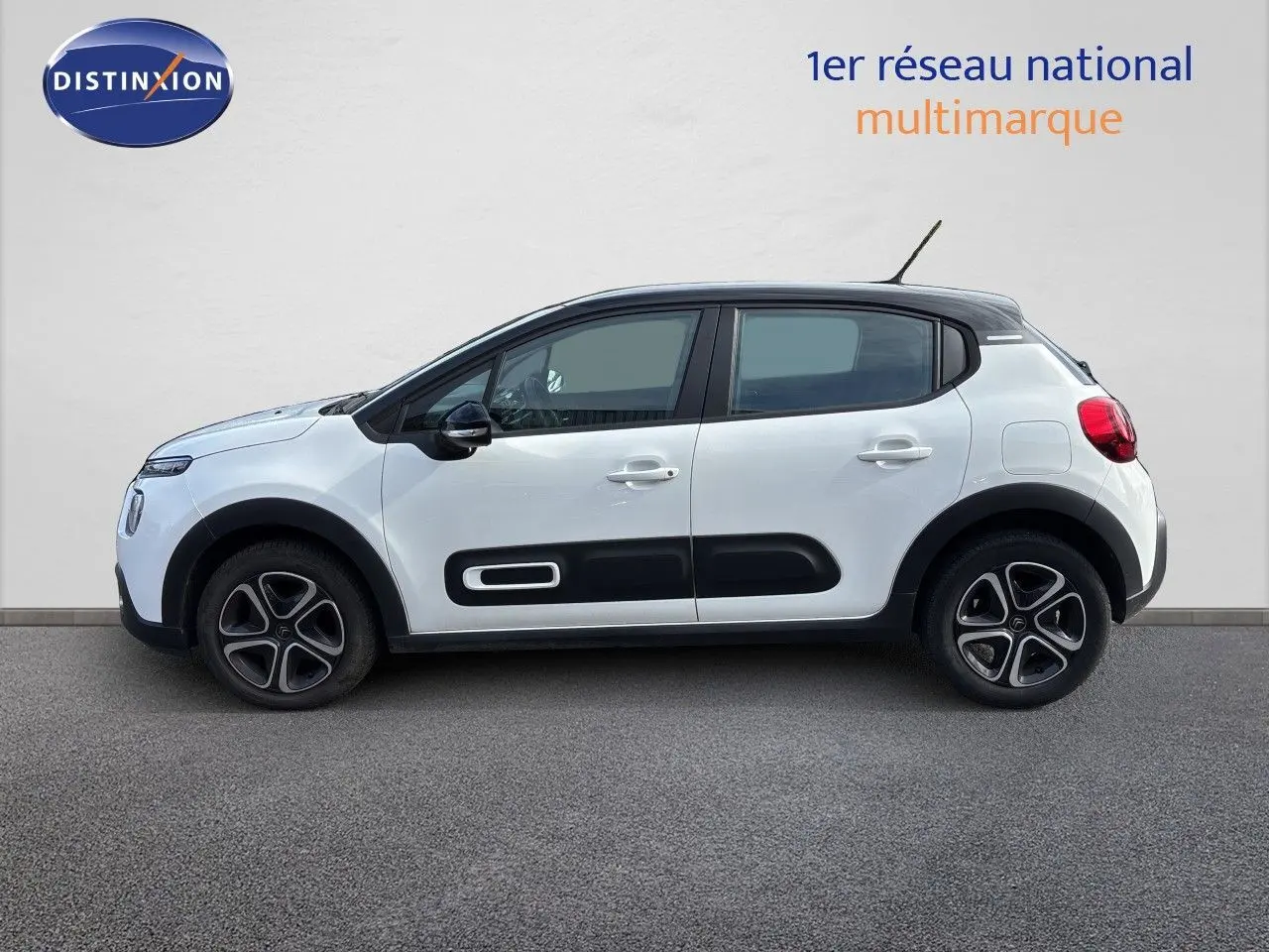 Profil droit d'une Citroën C3 blanche Banquise 2022 avec toit noir et protections latérales noires.