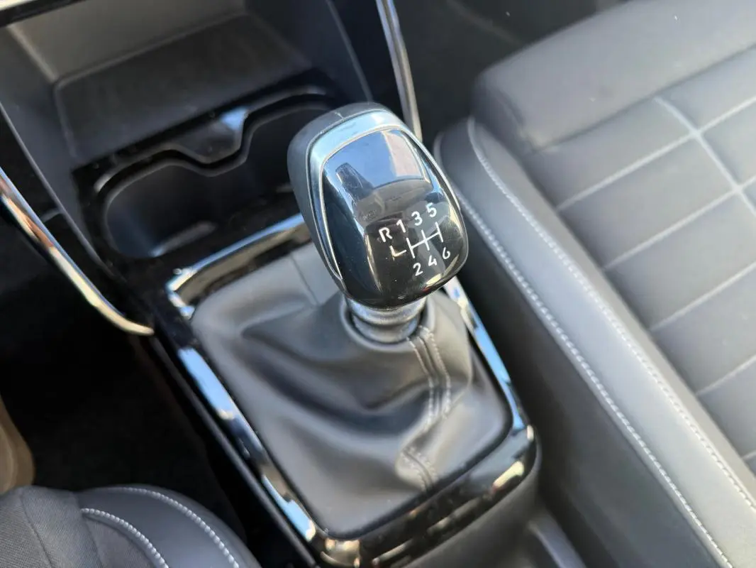 Gros plan sur le levier de vitesses manuel noir et la console centrale du Citroën C3 gris, intérieur moderne et soigné.