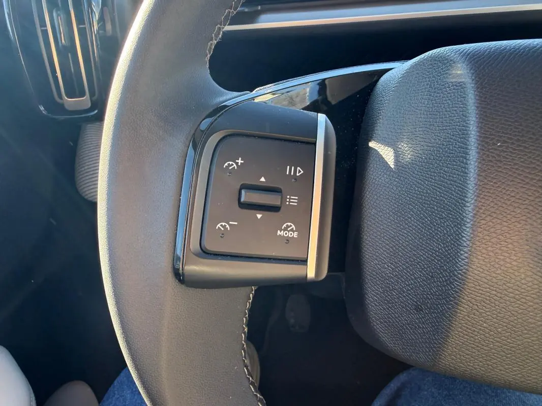 Gros plan sur les commandes de régulateur de vitesse au volant cuir noir de la Citroën C3 gris 2025.