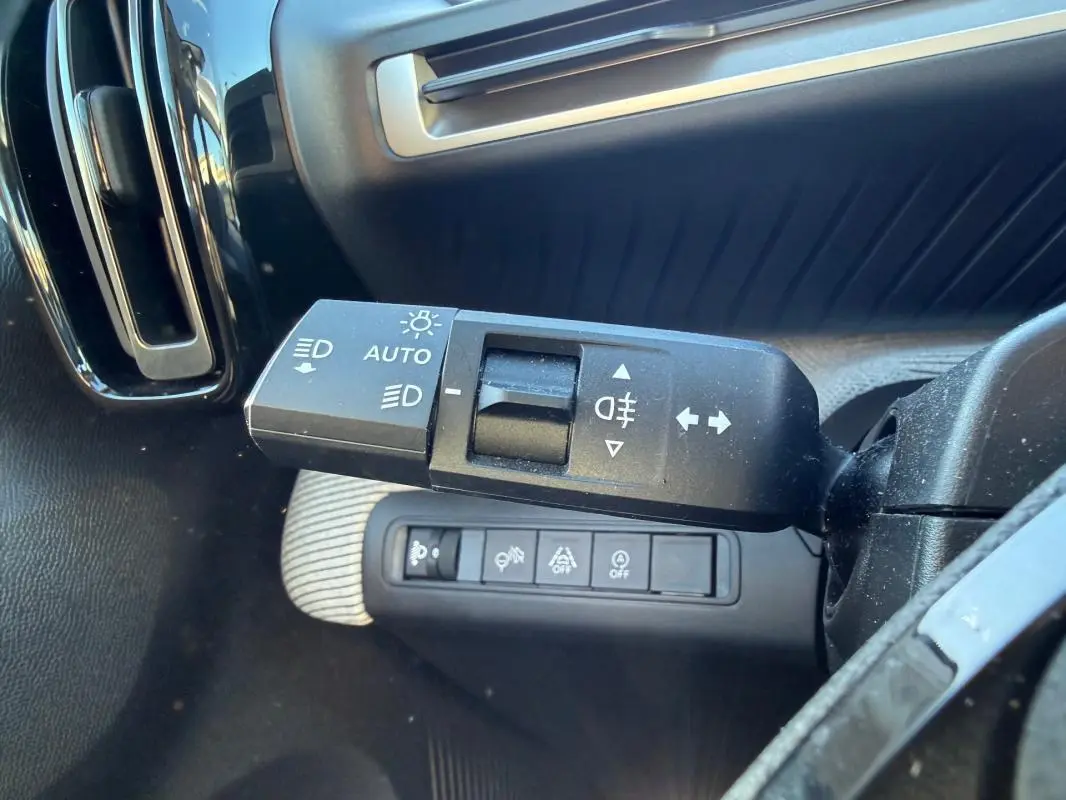 Gros plan sur la commande des feux et clignotants côté gauche du tableau de bord d'une Citroën C3 gris 2025.