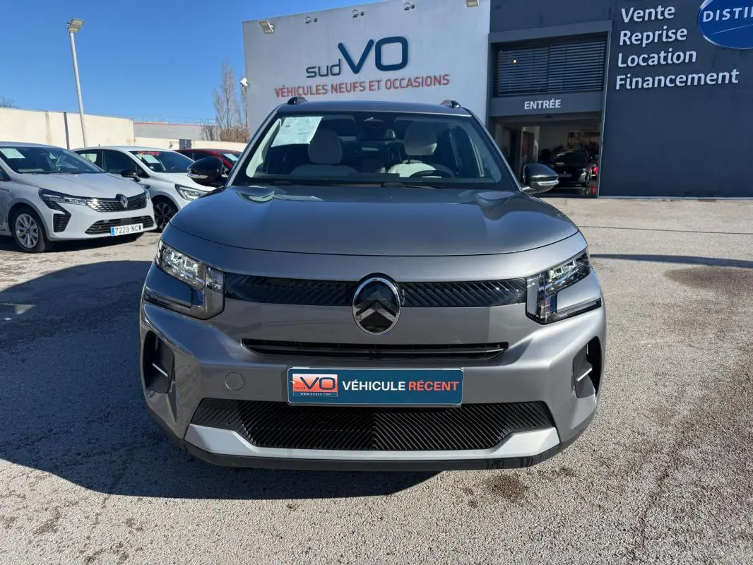 Vue avant d'une Citroën C3 Turbo 100 ch gris 2025 avec barres de toit et jantes alliage 17 pouces, stationnée en extérieur.
