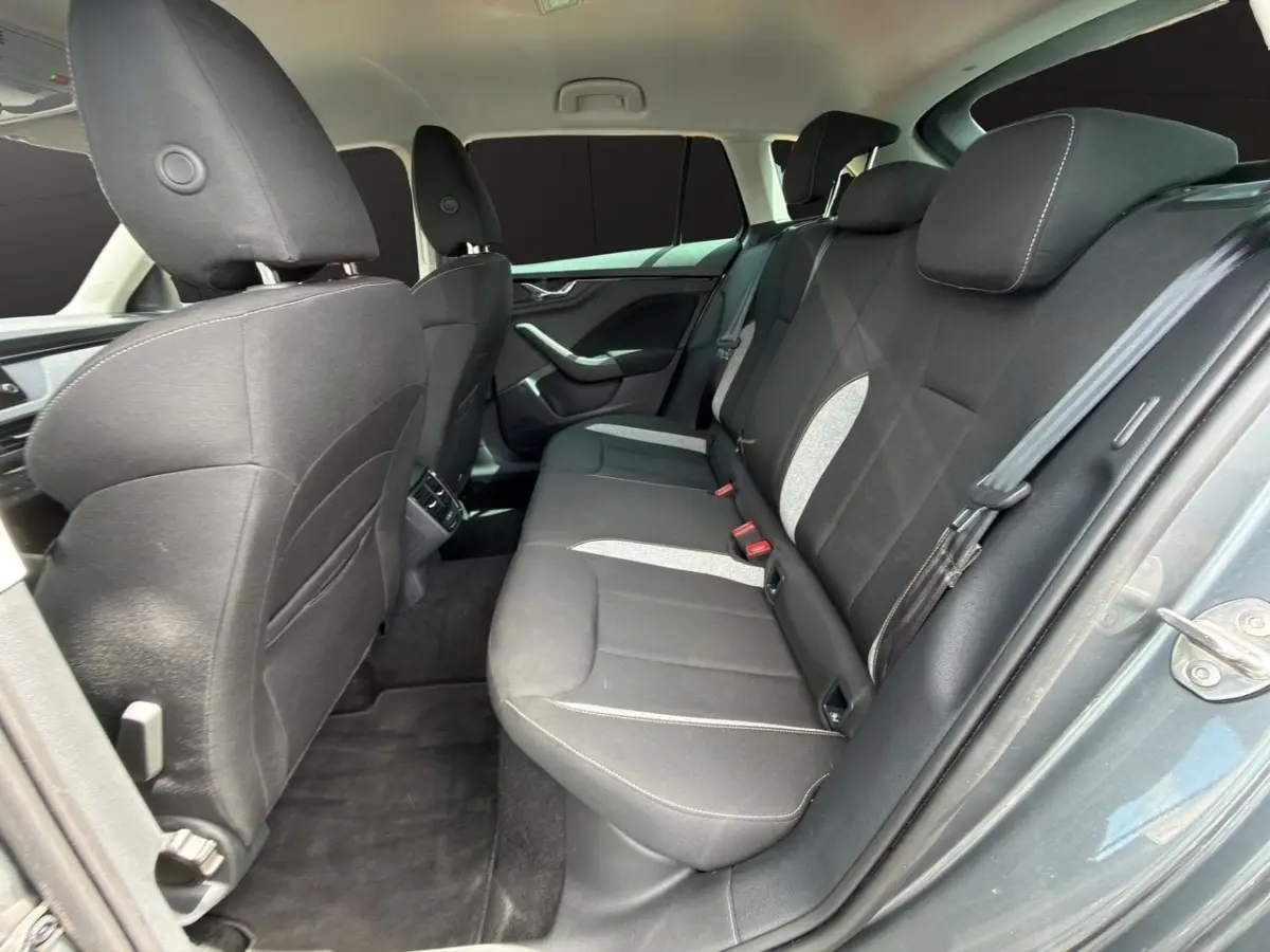 Vue intérieure arrière côté droit de la Skoda Scala gris foncé, montrant la banquette tissu noire avec inserts gris clair.
