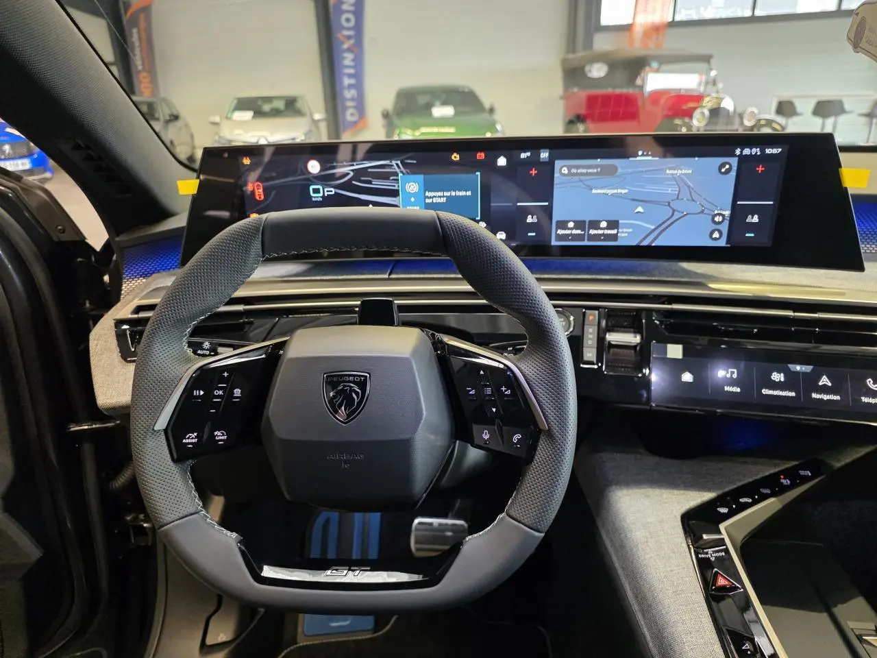 Vue intérieure centrée sur le volant compact du Peugeot 3008 gris titanium 2026 avec tableau de bord numérique large.