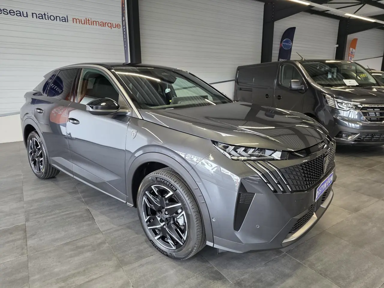 Peugeot 3008 Hybrid gris titanium en vue 3/4 avant droit, avec calandre noire et jantes alliage noires brillantes.
