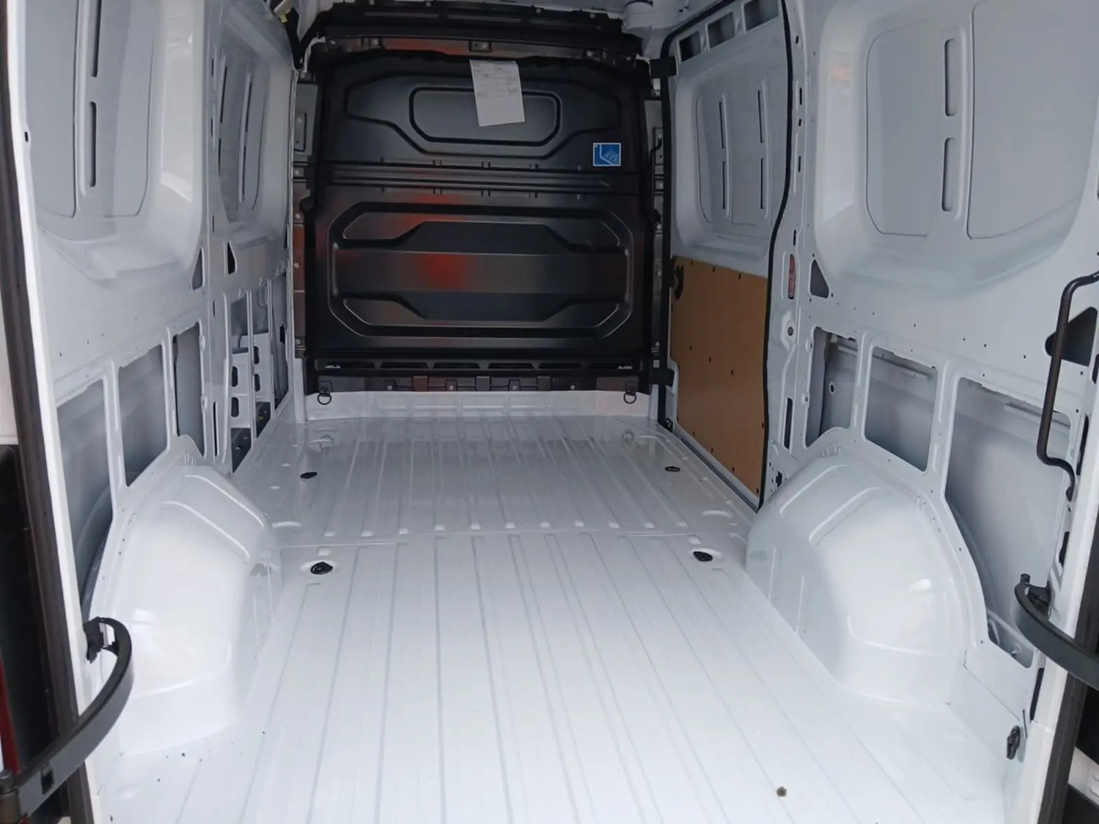 Vue intérieure arrière du Renault Master blanc L2H2 2026, montrant l'espace de chargement vide avec cloison noire.