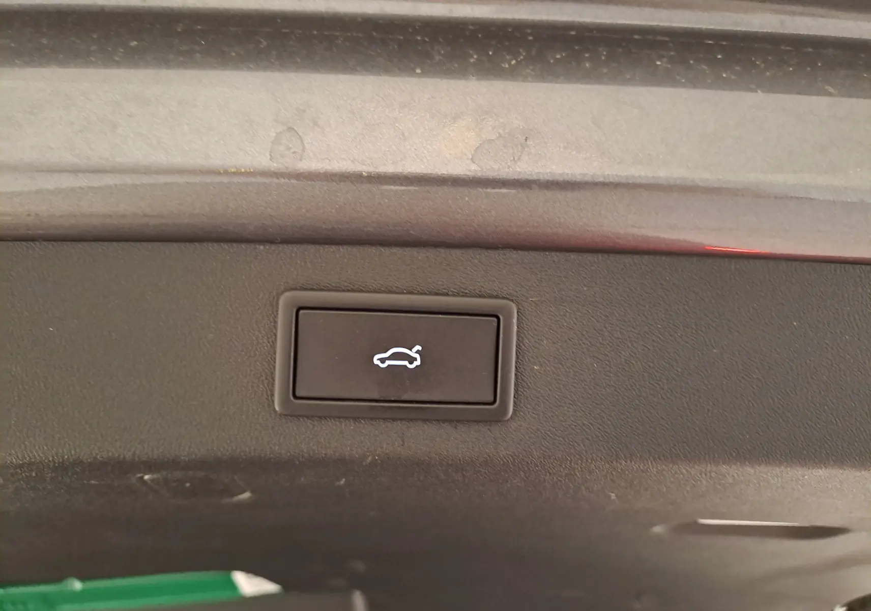 Bouton d'ouverture électrique du coffre sur la partie intérieure du hayon d'un Skoda Kodiaq gris graphite hybride rechargeable.