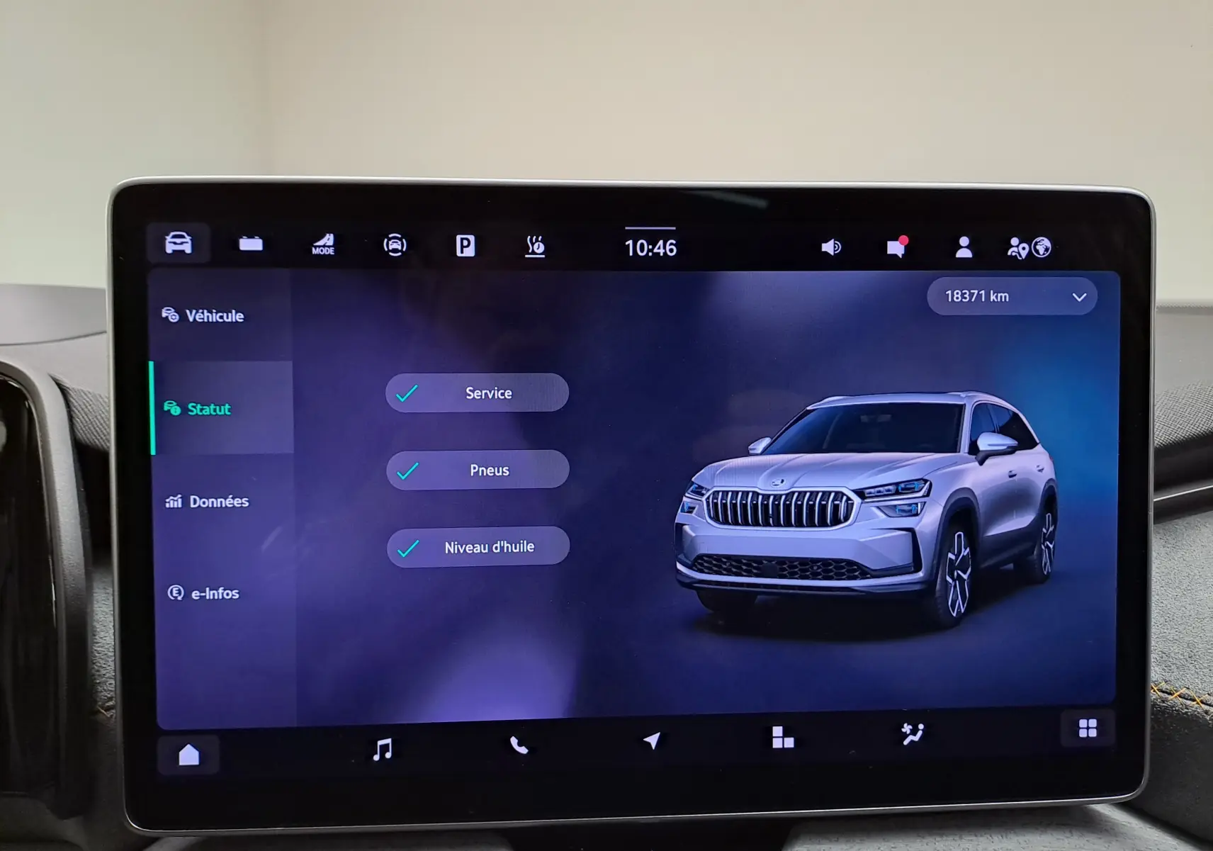 Écran tactile intérieur affichant une image 3/4 avant d'un Skoda Kodiaq gris graphite avec calandre distinctive.
