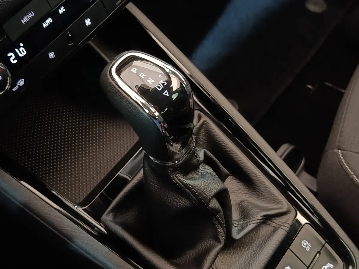 Gros plan sur le levier de vitesse automatique noir et chrome dans l’habitacle sombre d’une Skoda Scala 2025.
