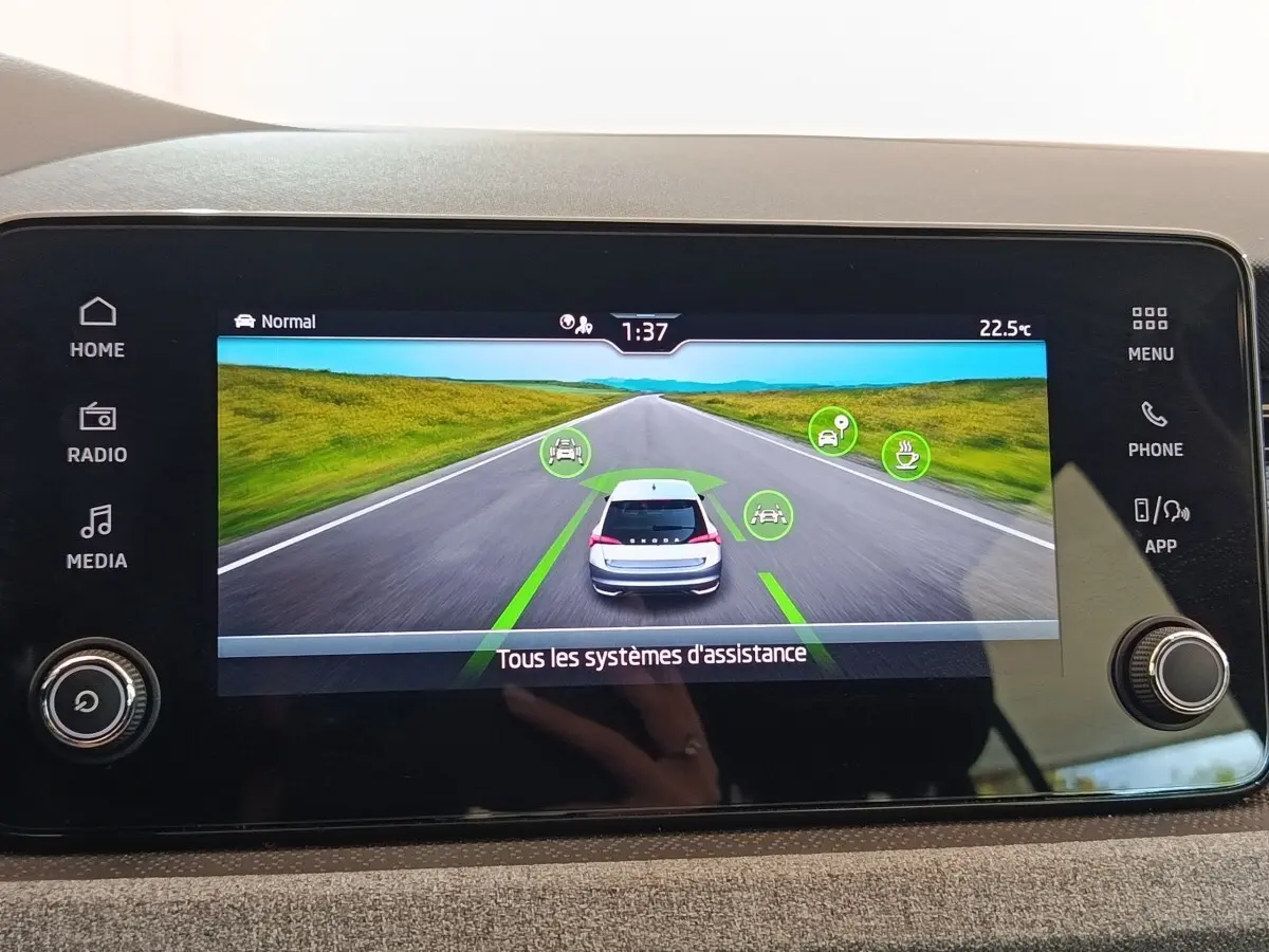 Écran tactile central affichant les systèmes d'assistance du Skoda Scala 2025 en vue arrière virtuelle.