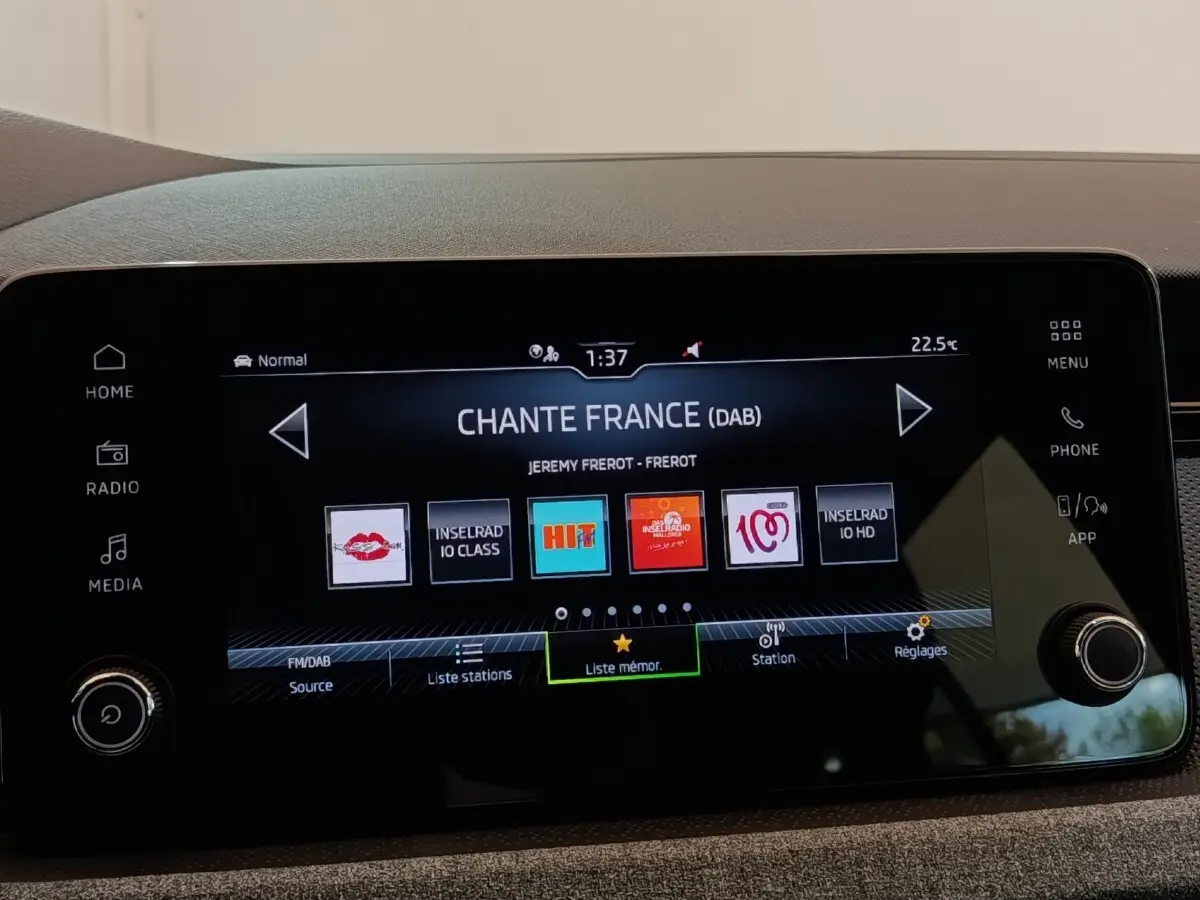 Écran tactile central de la Skoda Scala 2025 affichant la radio numérique avec menu et boutons latéraux visibles.