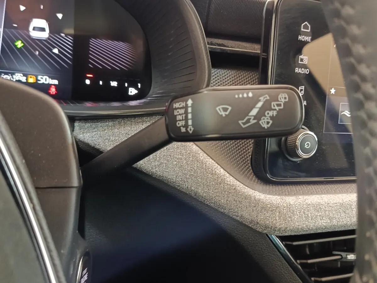 Gros plan sur la commande des essuie-glaces à gauche du volant dans l’habitacle du Skoda Scala bleu 2025.
