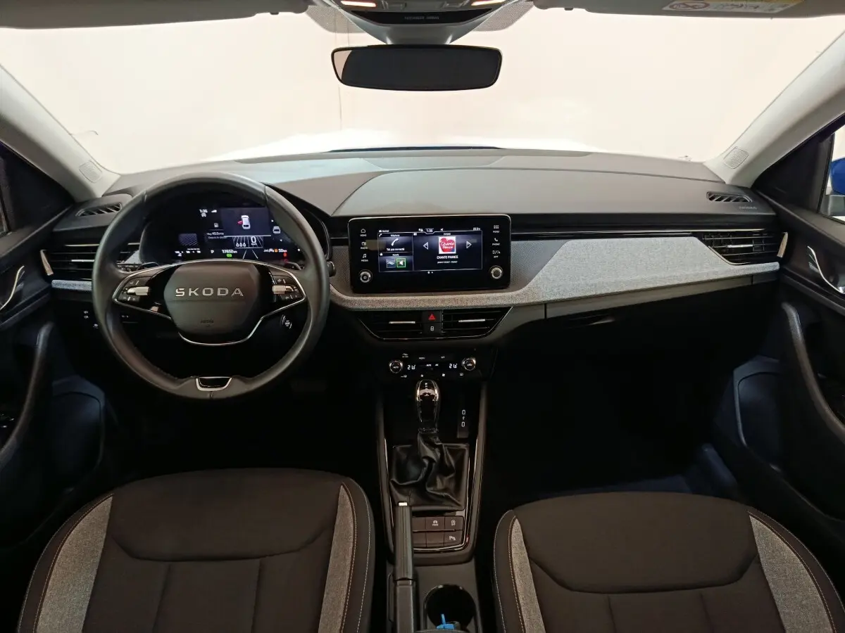 Vue intérieure avant du Skoda Scala 2025, tableau de bord moderne avec écran tactile central et volant multifonctions.