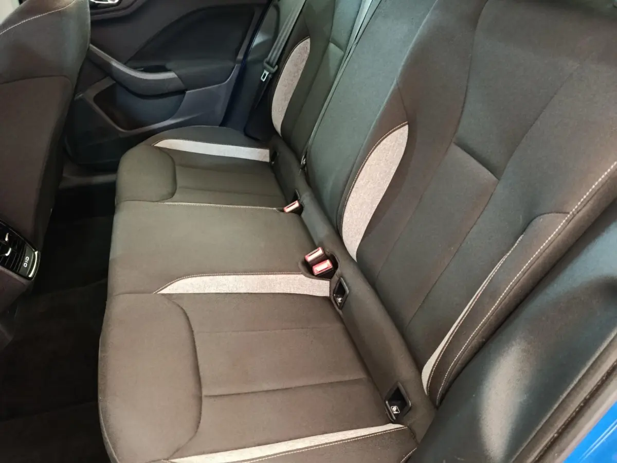 Vue intérieure côté droit des sièges arrière gris foncé avec inserts clairs d'une Skoda Scala bleu 2025.