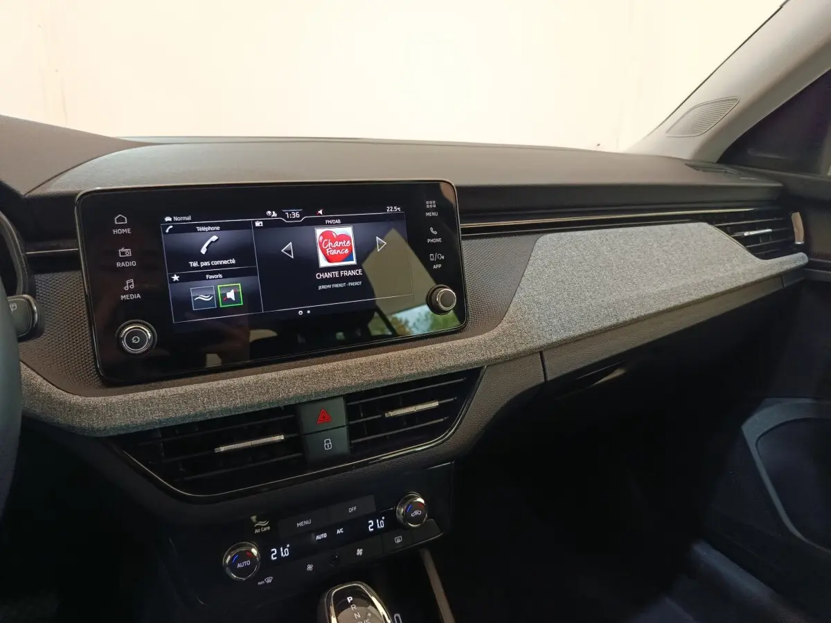 Vue intérieure côté passager du tableau de bord gris clair et écran tactile central de la Skoda Scala 2025.