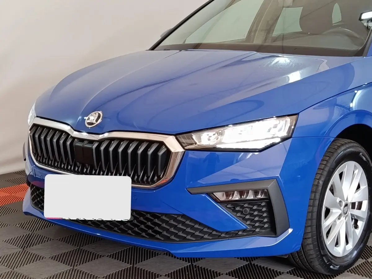 Vue avant droite d'une Skoda Scala bleu vif avec calandre noire et phares LED allumés.