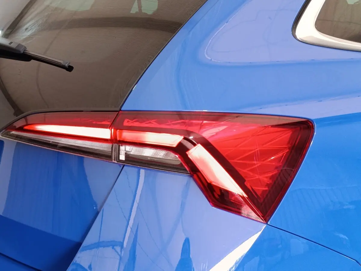 Gros plan sur le feu arrière droit rouge d’une SKODA SCALA bleu 2025, soulignant la ligne anguleuse de la carrosserie.