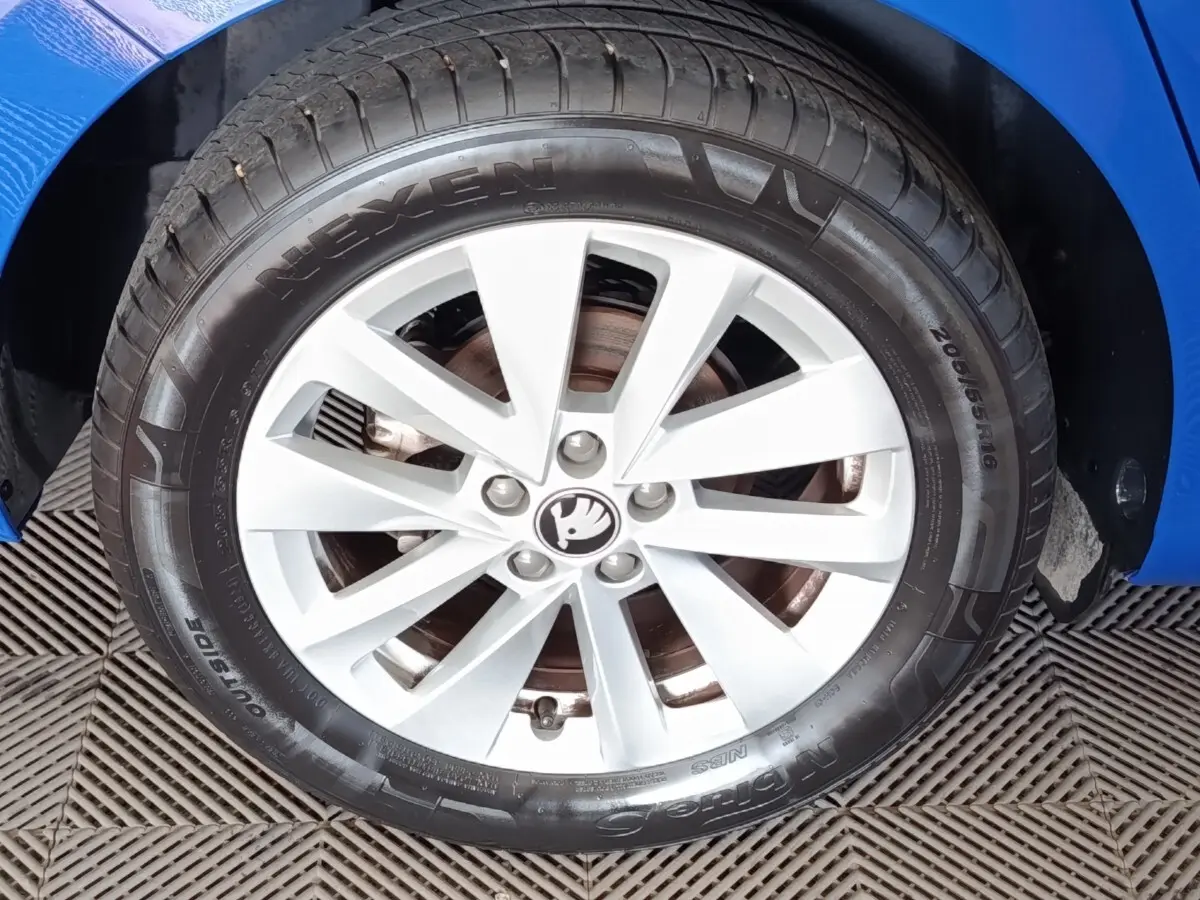 Gros plan sur la roue avant droite d’une Skoda Scala bleu 2025 avec jante alliage argentée et pneu Nexen.