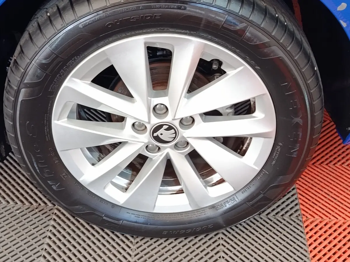 Gros plan sur la roue avant droite avec jante alliage argentée du Skoda Scala bleu 2025.