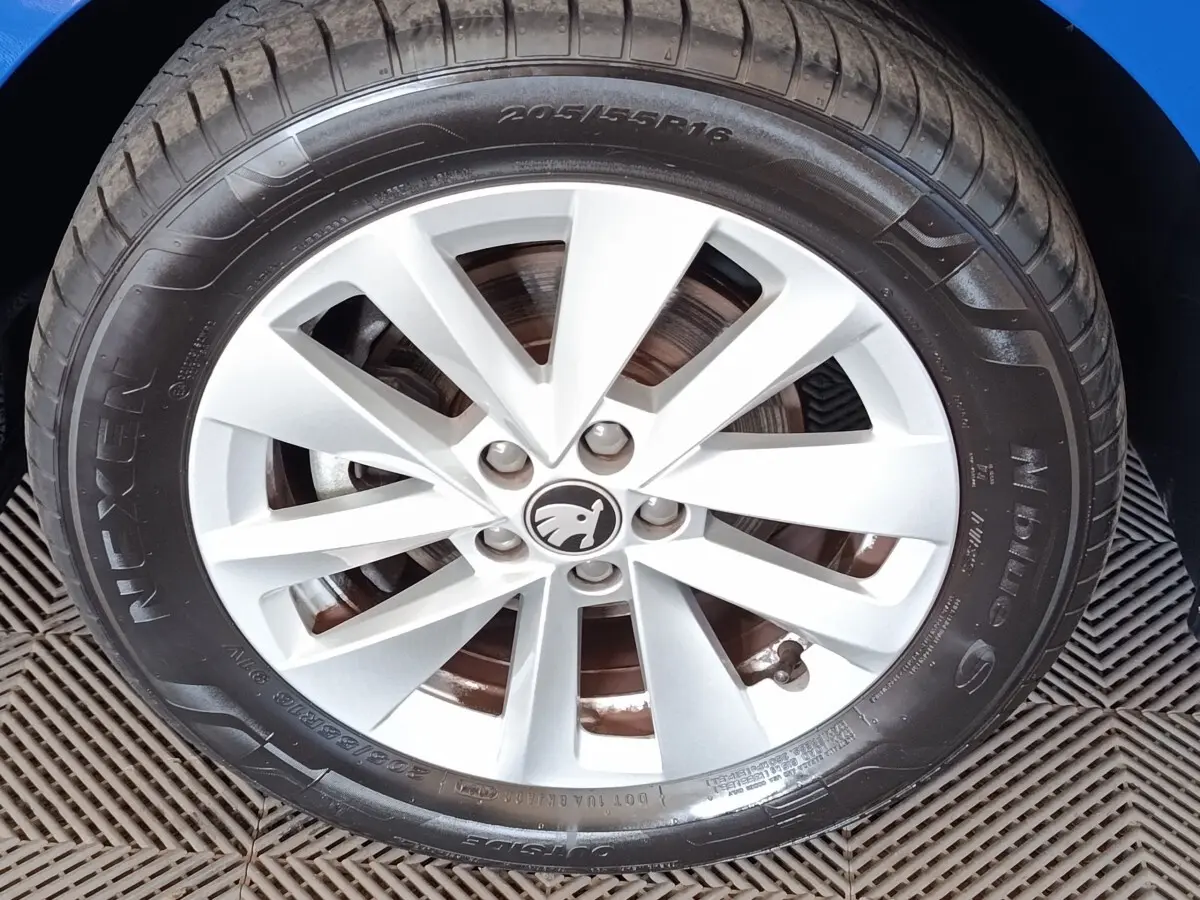Gros plan sur la roue avant droite de la Skoda Scala bleue, mettant en valeur la jante alliage argentée et le logo central.