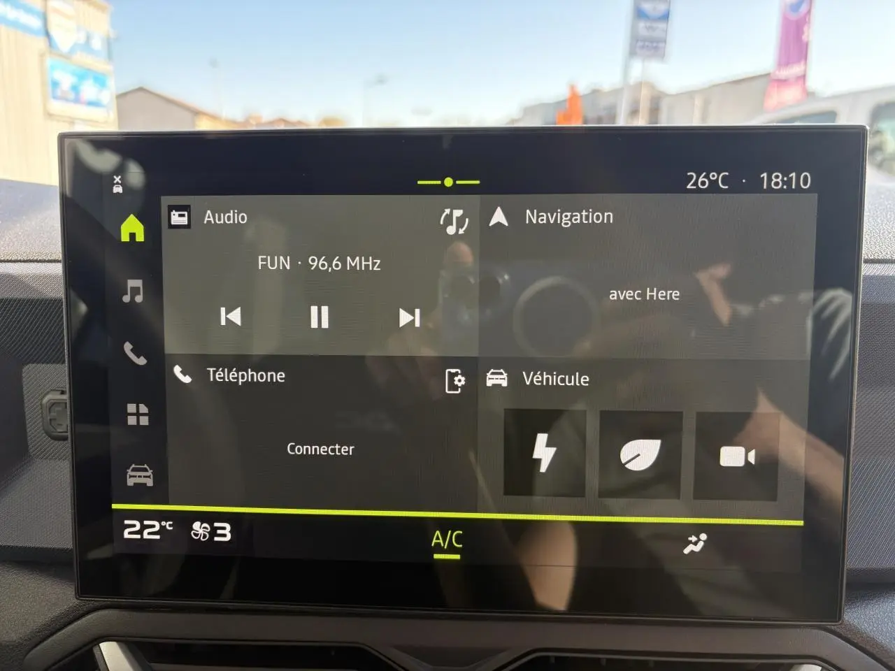 Écran tactile central du Dacia Duster 2024 affichant radio, navigation et climatisation en intérieur noir.