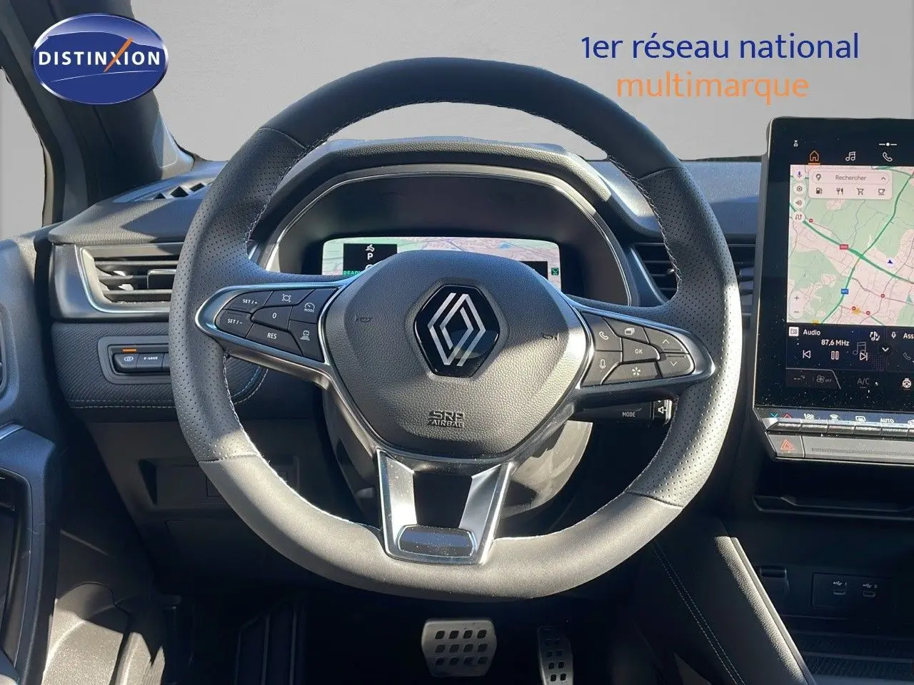 Vue rapprochée du volant en cuir perforé de la Renault Captur E-Tech hybride avec tableau de bord numérique et écran tactile GPS.