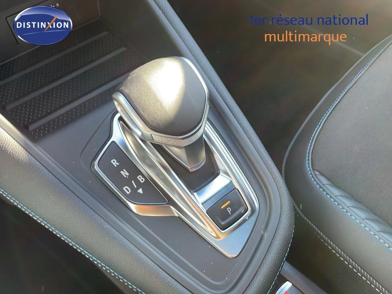 Le levier de vitesse automatique du Renault Captur E-Tech hybride, entouré de coutures bleues sur la console noire.