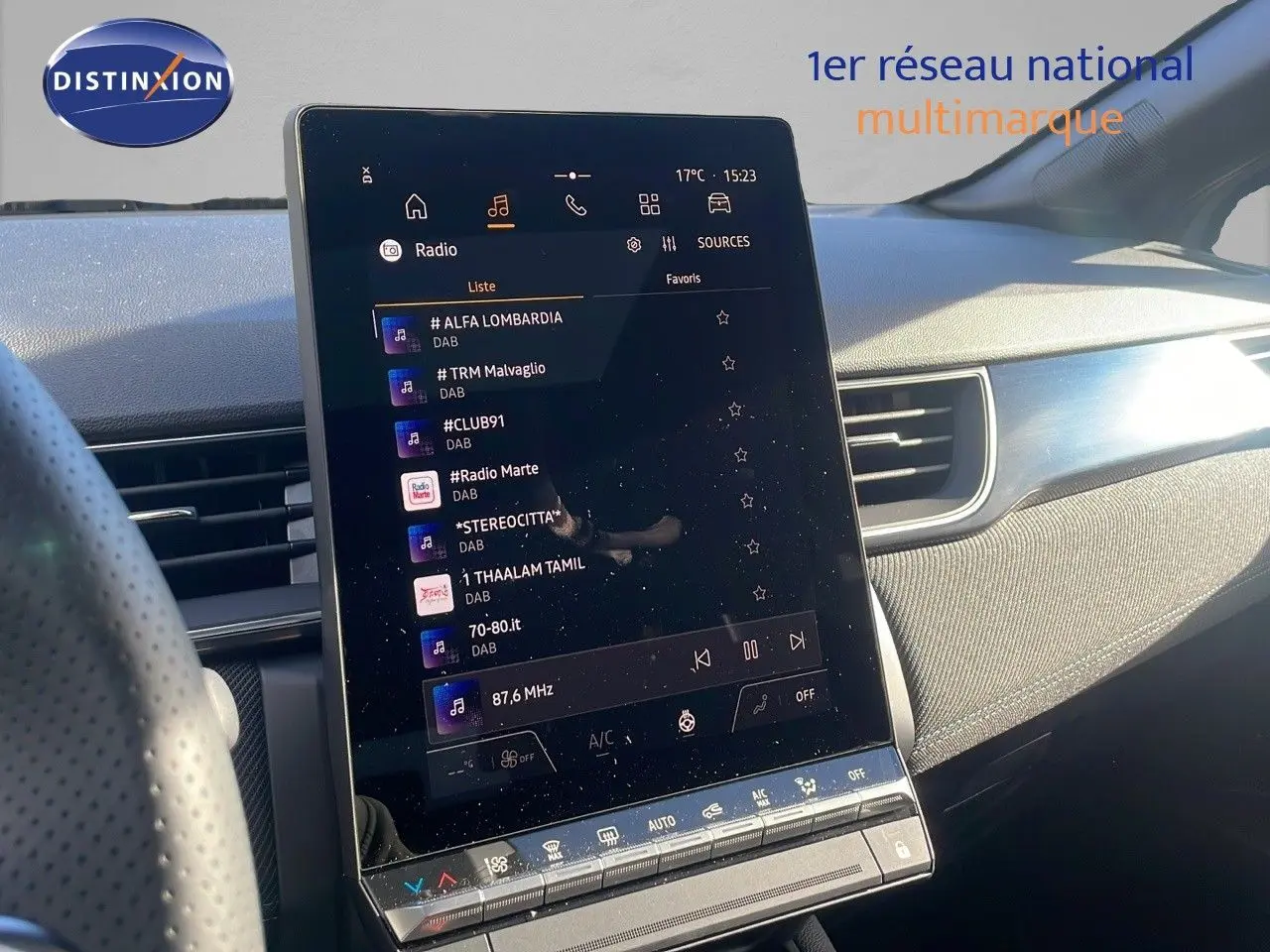 Écran tactile central allumé dans l'habitacle d'une Renault Captur gris rafale avec toit noir, vue côté conducteur.