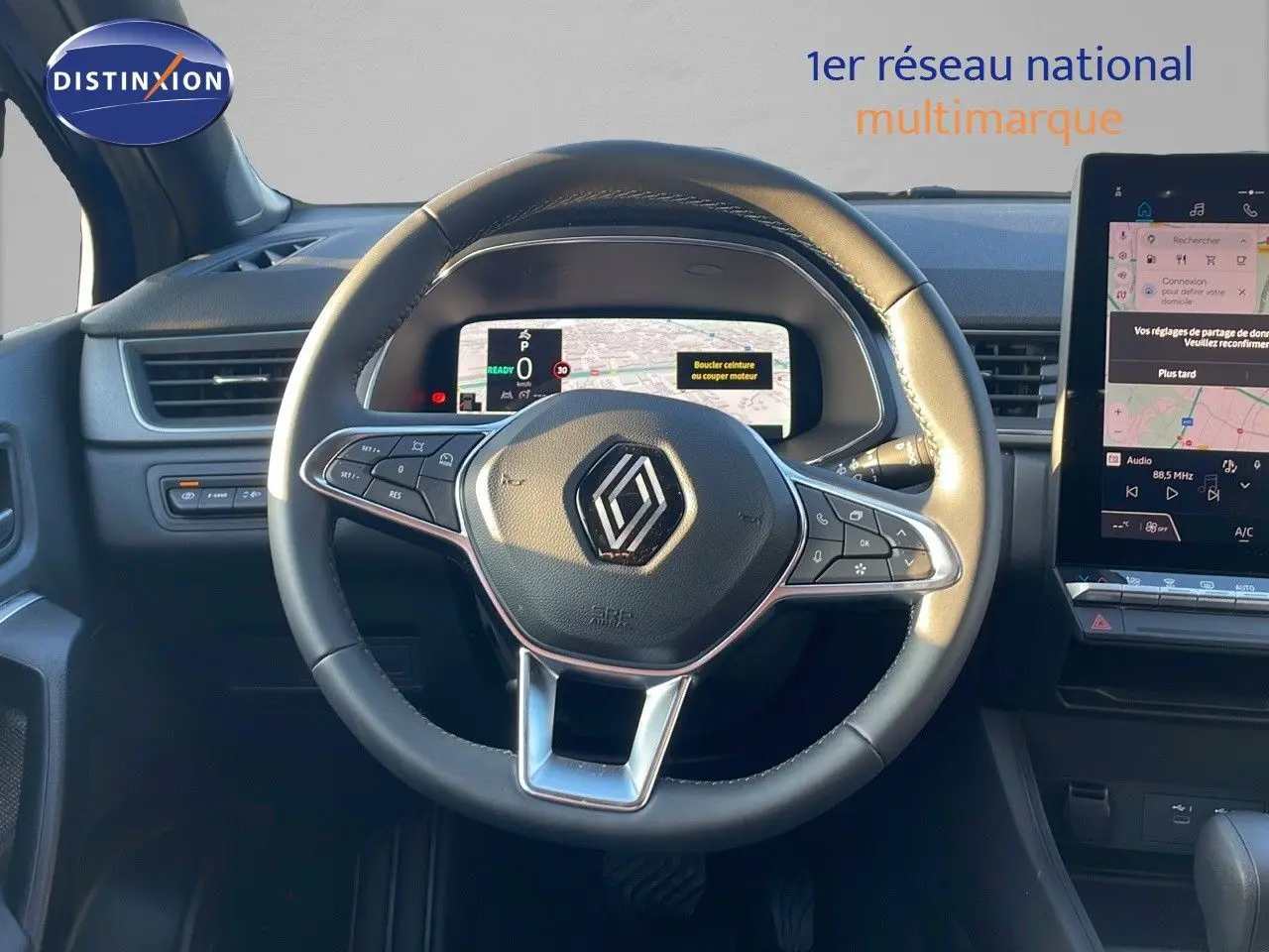 Vue rapprochée du volant cuir noir du Renault Captur E-Tech Hybrid avec tableau de bord numérique et écran tactile central.