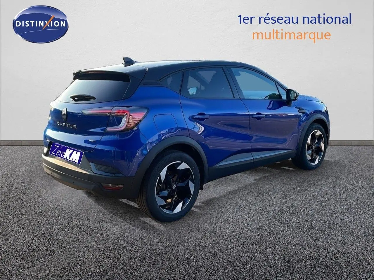 Renault Captur E-Tech hybride bleu Iron Metal avec toit noir, vue 3/4 arrière côté droit, jantes bi-ton distinctives.