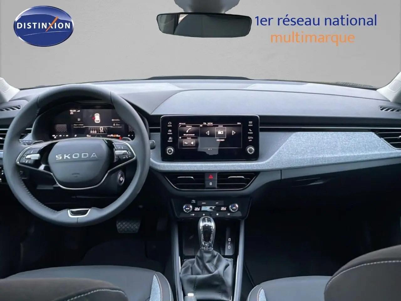 Vue intérieure frontale du tableau de bord gris et noir du Skoda Kamiq avec écran tactile et volant multifonction.