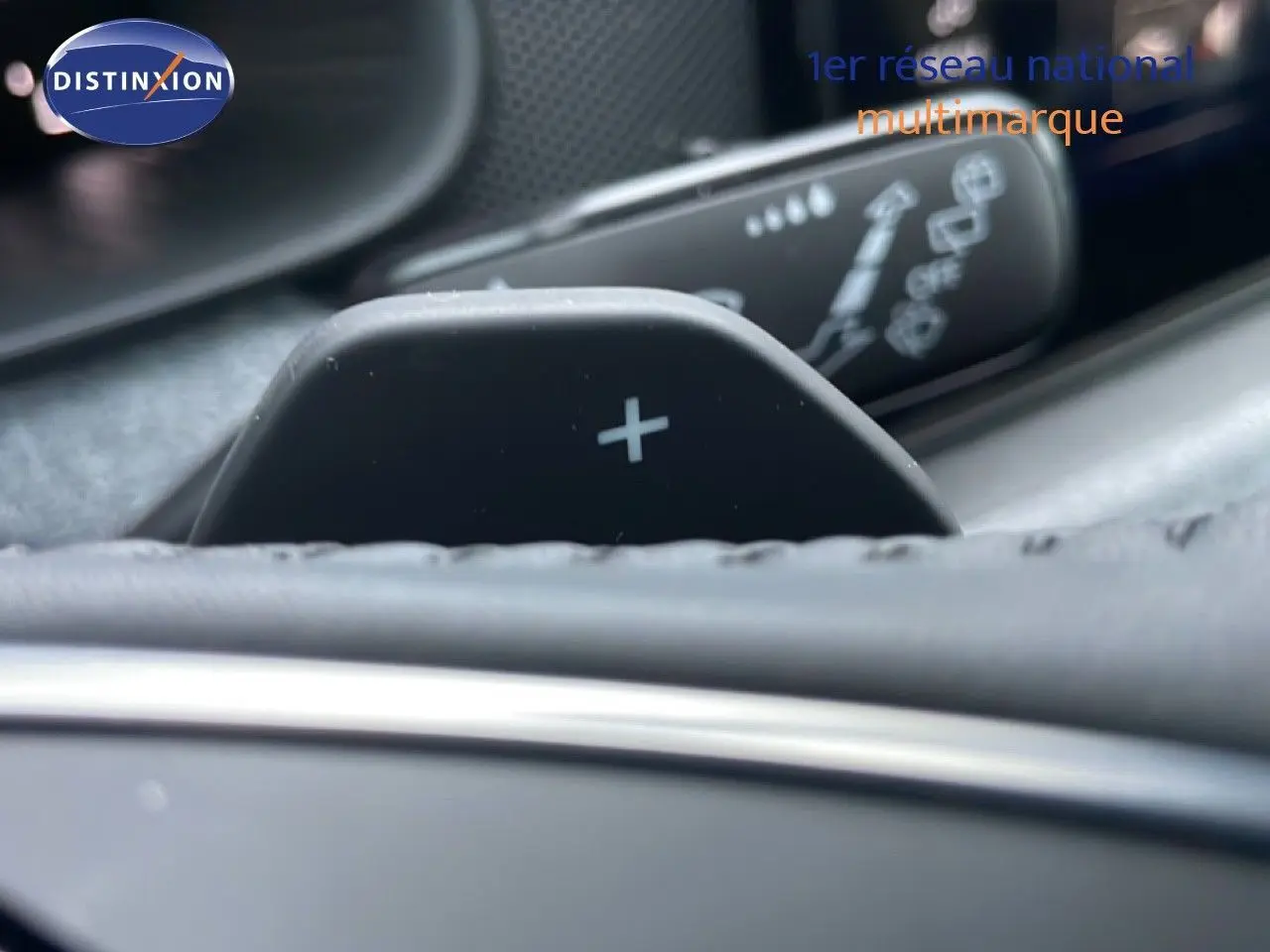 Gros plan sur la palette de changement de vitesse "+" dans l'habitacle d'une Skoda Kamiq gris graphite.