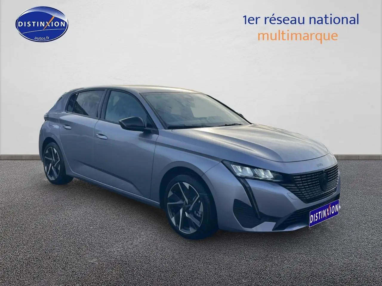 Peugeot 308 gris artense vue 3/4 avant droit, avec calandre noire et jantes alliage distinctives.