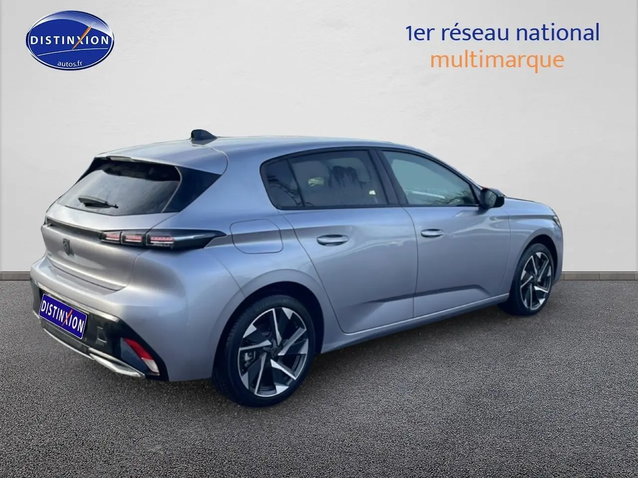 Vue 3/4 arrière droite d'une Peugeot 308 gris artense avec jantes alliage et feux arrière LED distinctifs.