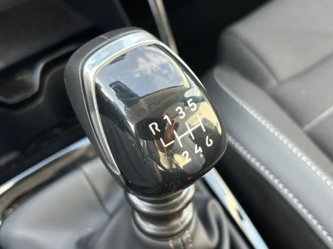 Gros plan sur le levier de vitesses manuel noir de la Citroën C3 Turbo 100 ch, intérieur cuir gris visible en arrière-plan.