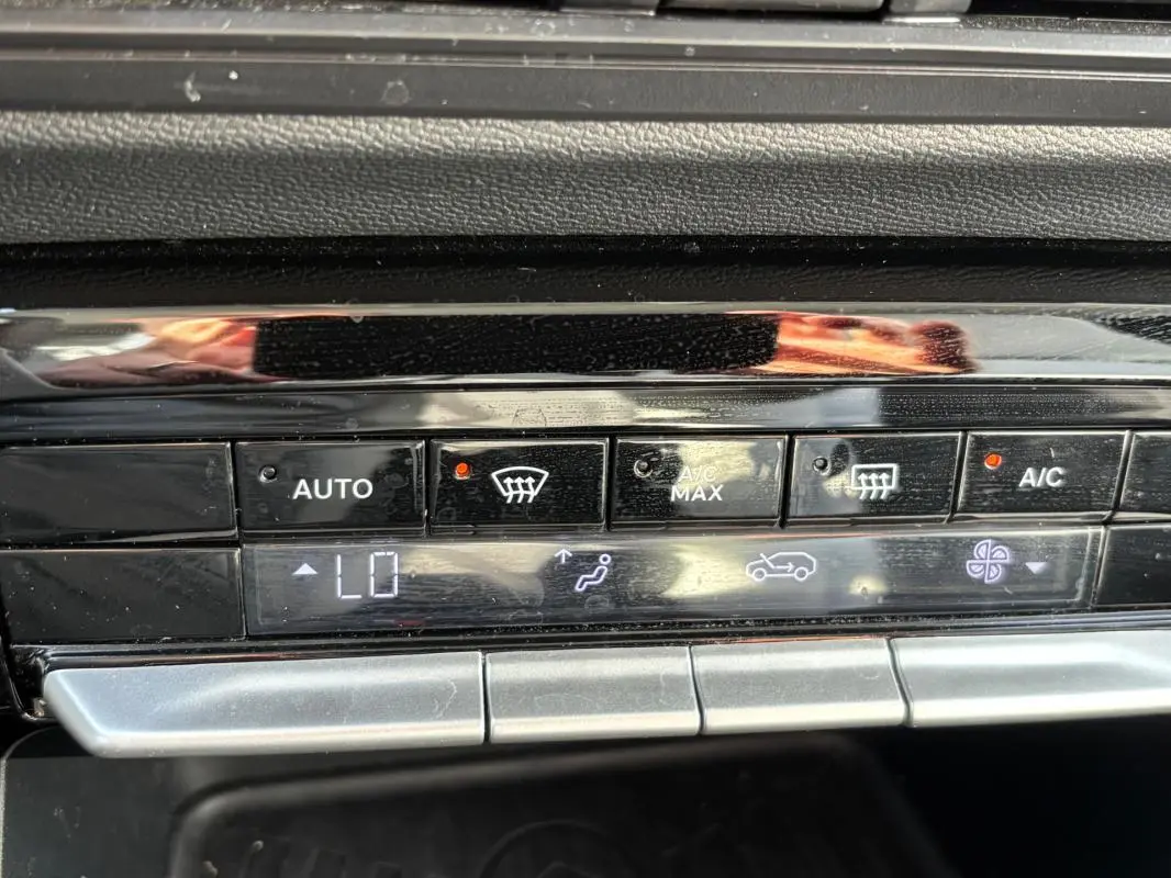 Gros plan sur la console de climatisation automatique de la Citroën C3 bleu, affichant le réglage "LO" et plusieurs boutons actifs.
