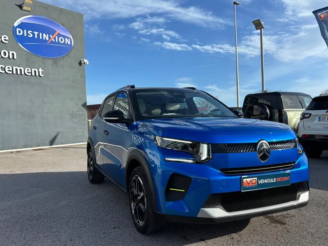 Citroën C3 Turbo 100 ch bleu en 3/4 avant droit, avec jantes alliage 17 pouces et barres de toit visibles.