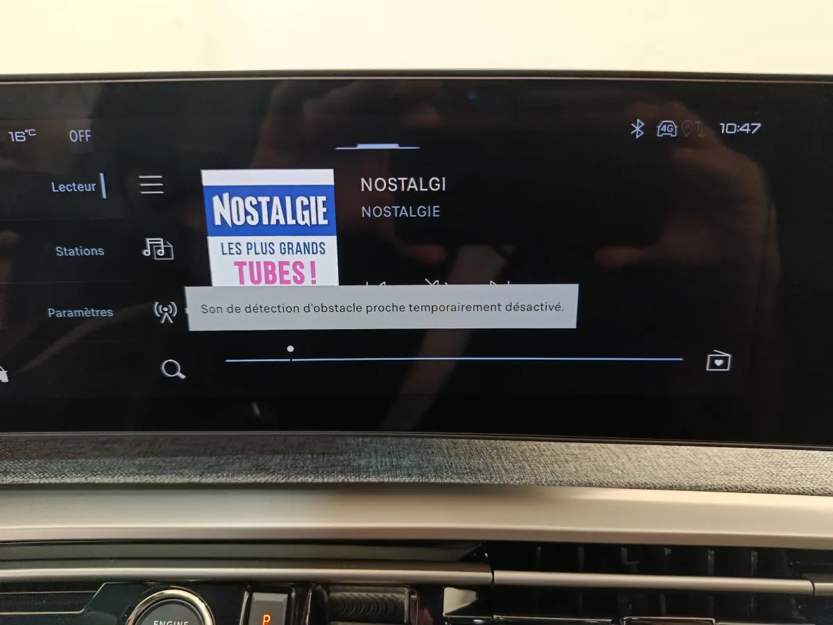 Écran tactile central du Peugeot 3008 gris clair, affichant la radio Nostalgie avec interface moderne.