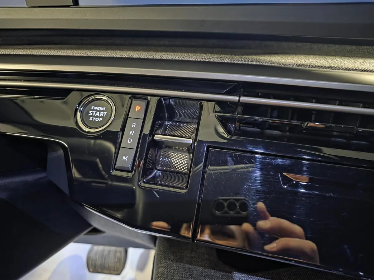 Détail de la console centrale noire laquée du Peugeot 5008 2025, avec bouton start/stop et sélecteur de boîte auto.