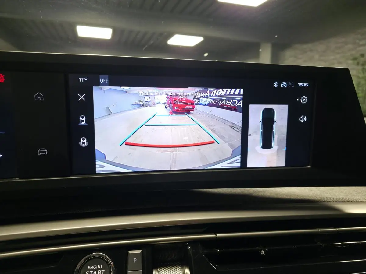 Écran de recul montrant une Peugeot 5008 grise vue de l'arrière dans un garage, avec guidage de trajectoire.