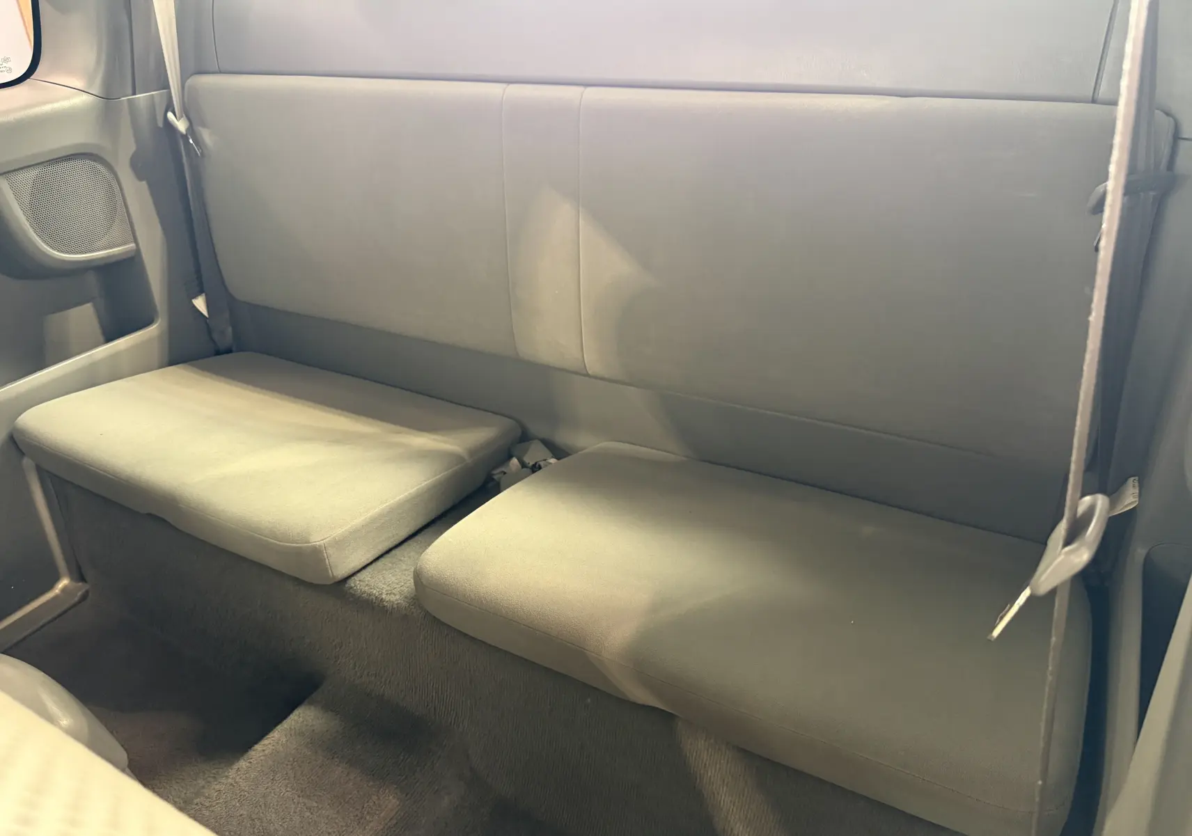 Vue intérieure arrière du Toyota Hilux X-Tra Cabine 2009 gris, montrant les sièges arrière simples et épurés.