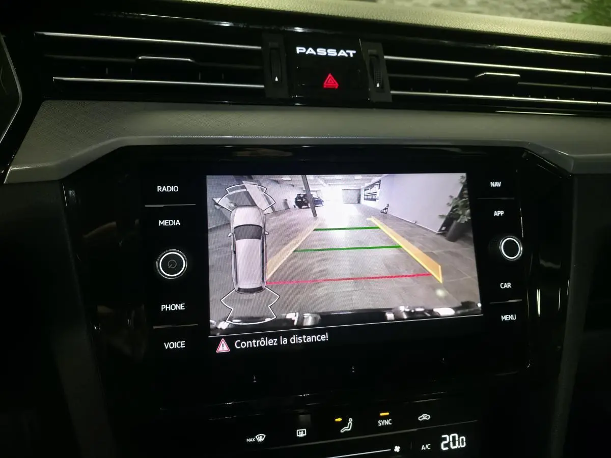 Vue rapprochée de l’écran tactile central de la Volkswagen Passat SW 2024 affichant la caméra de recul avec guidage coloré.