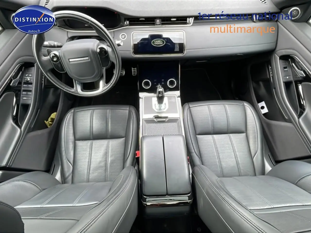 Vue intérieure du Range Rover Evoque 2020 noir, montrant les sièges cuir noirs et la console centrale moderne.