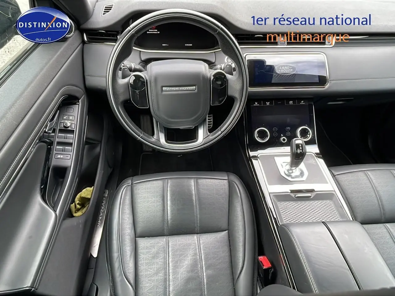 Intérieur noir du Range Rover Evoque 2020, vue plongeante sur le volant, sièges cuir et console centrale moderne.