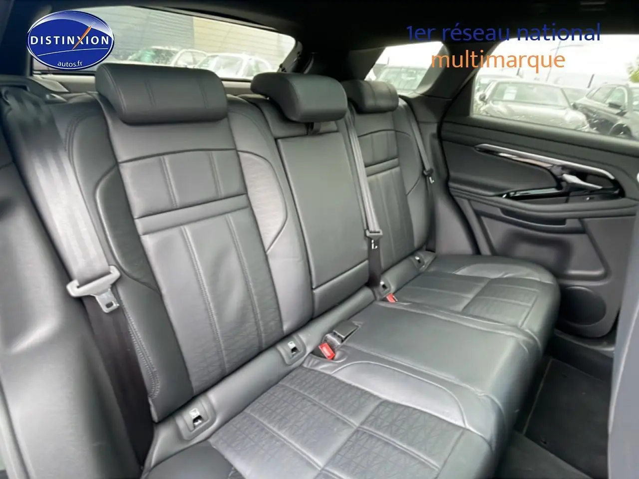 Vue intérieure des sièges arrière en cuir noir du Range Rover Evoque 2020, avec accoudoir central et ceintures visibles.