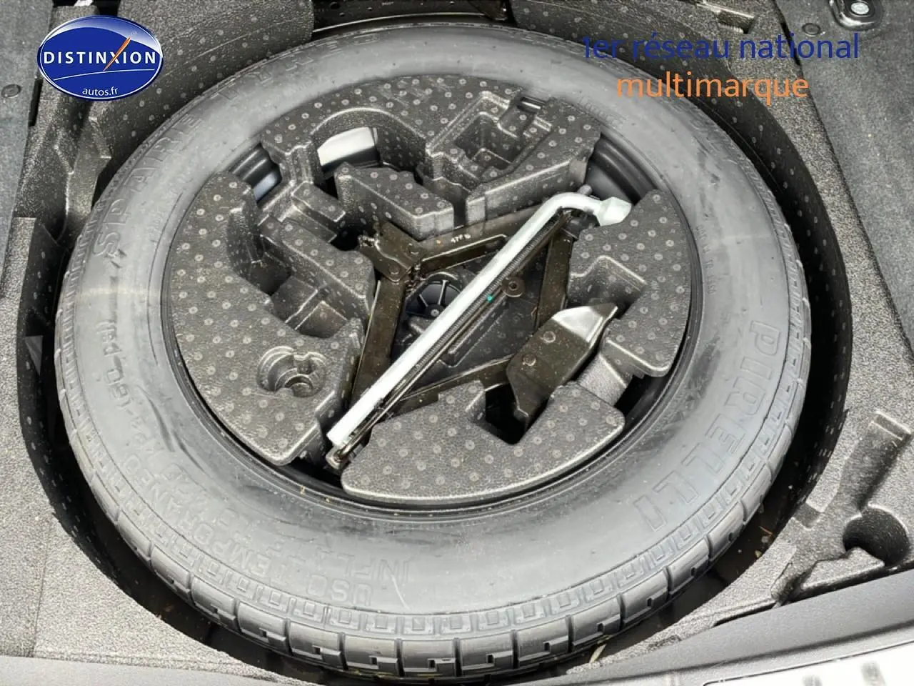 Roue de secours avec outillage intégré dans le coffre d’un Range Rover Evoque noir, vue de dessus.