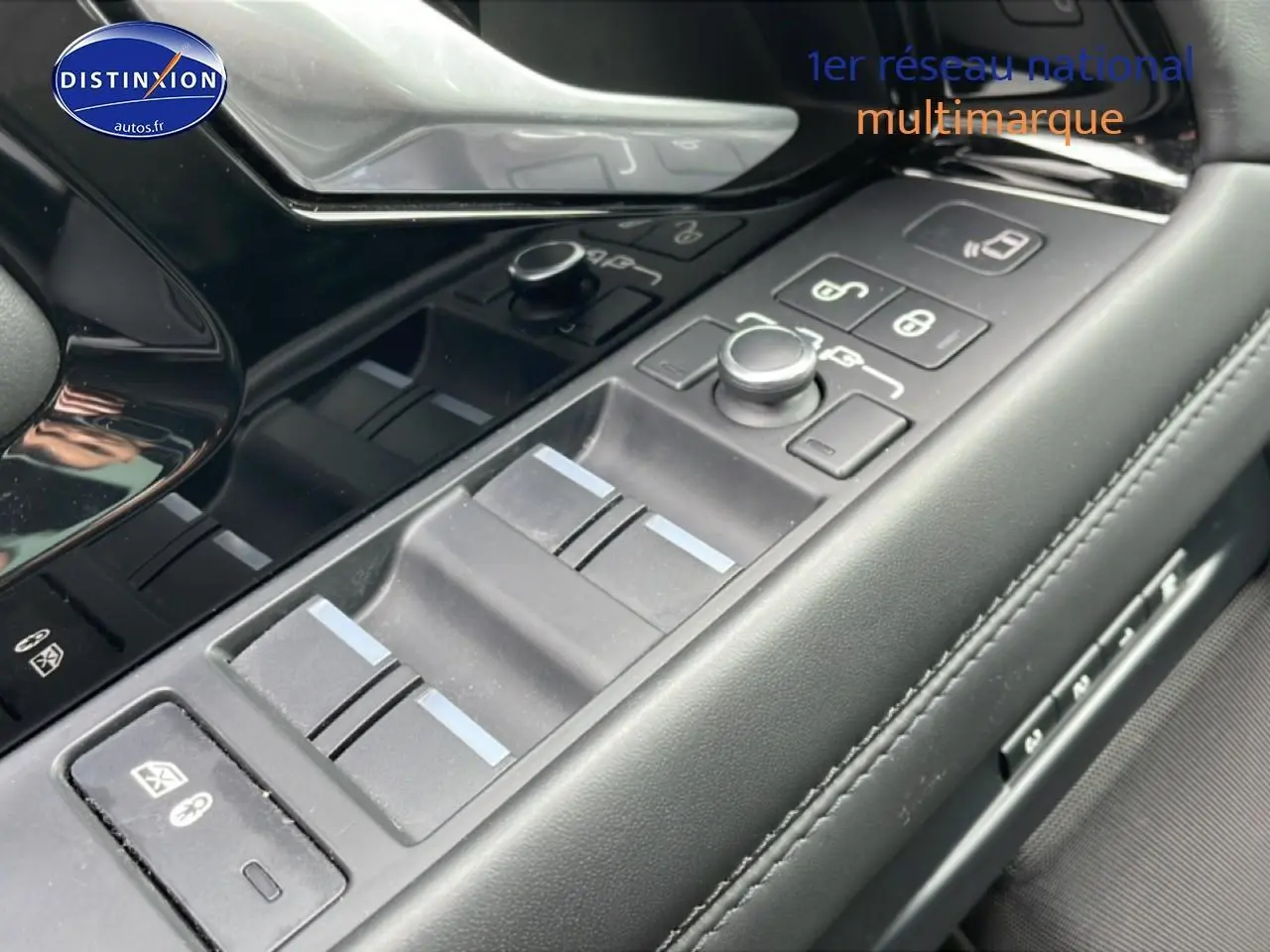 Gros plan sur les commandes de vitres et rétroviseurs côté conducteur du Range Rover Evoque noir, intérieur cuir noir.